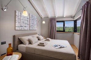 A modern bedroom with a large bed, a nightstand, a reading lamp, and a window with curtains. - Villa Iron Lady Labin – Private Pool & Sea View, Labin, Croatia (Labin)