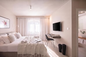 A hotel room with a bed, a desk, a chair, a TV, and a bathroom visible through an open door. - Villa Baracchi – 4 BDR Pool Villa with Sauna in Kršan, Čepić, Croatia (Čepić)