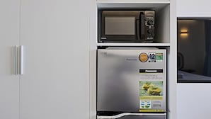 Una cocina con refrigerador y microondas integrados.