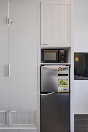 A kitchen with a built-in refrigerator and microwave.