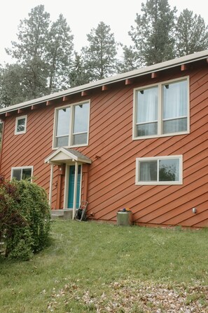 A two-story house with a red siding exterior, a front porch, and a blue door. - Entire home in Moscow, ID (Moscow)