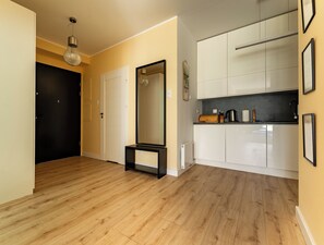 Eine moderne Küche mit weißen Schränken, einer schwarzen Arbeitsplatte und einem Holzboden.