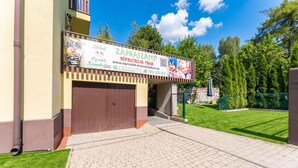 A building with a signboard advertising recruitment services, a gated entrance, and a paved driveway leading to the entrance. - Woronicza Urban Studio #1 (Kraków)