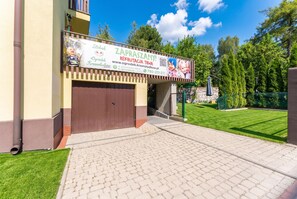 A building with a signboard advertising recruitment services, a gated entrance, and a paved driveway leading to the entrance. - Woronicza Urban Studio #1 (Kraków)