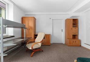 A room with a desk, a chair, and wooden cabinets. - Woronicza Urban Studio #1 (Kraków)