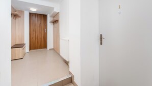 A hallway with a wooden door, a radiator, and a bench. - Woronicza Urban Studio #1 (Kraków)
