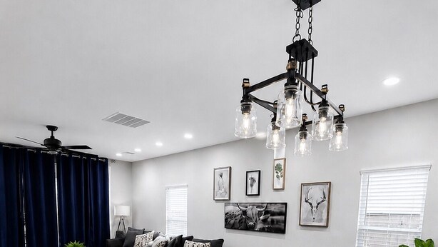 A modern living room with a dining area, dark wood flooring, and a ceiling fan. - The Backyard Cantina Walk to Fair Park (Dallas)