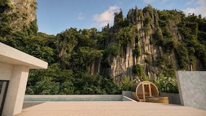 A modern building with a pool and a view of a forested cliff. - Villa V The One and Only, Managed by H Hospitality (El Nido)