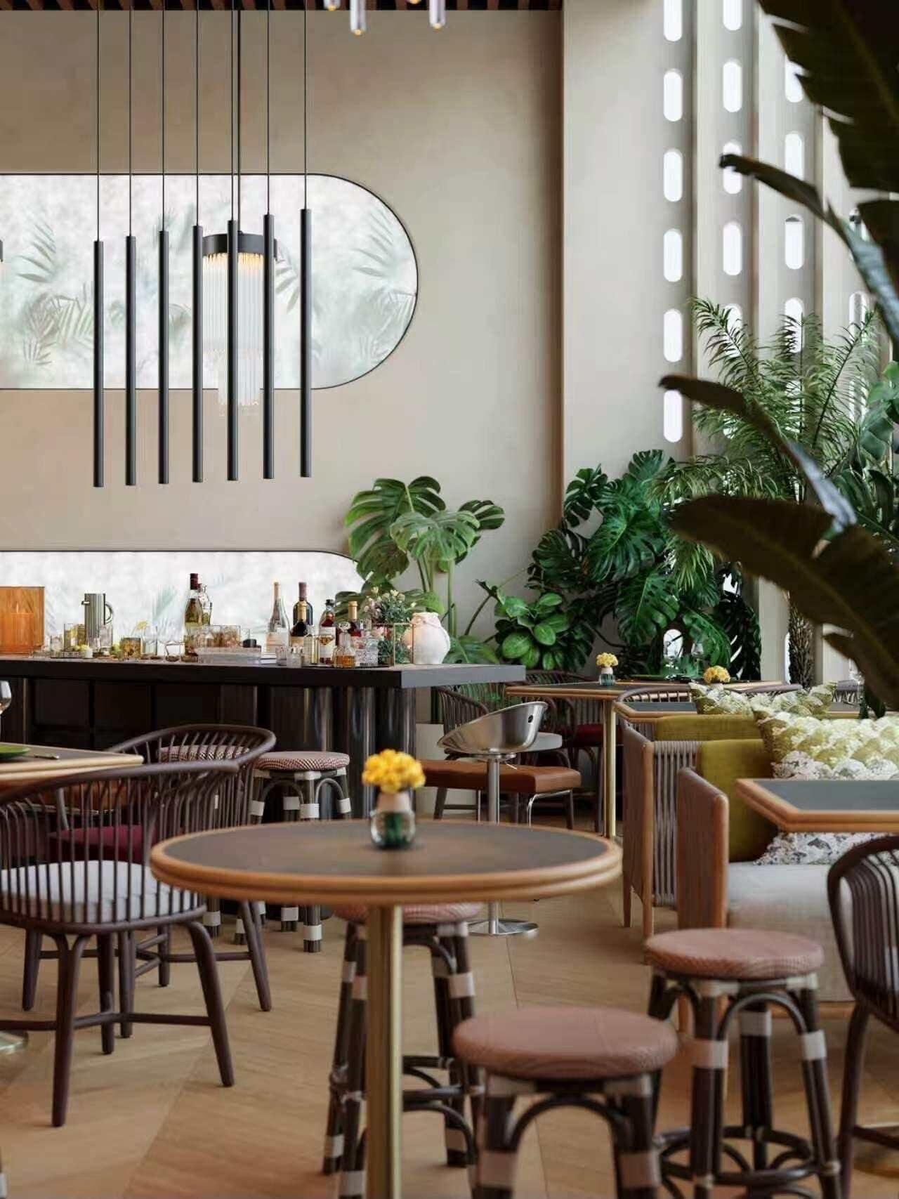 A modern bar area with high stools, a counter with bottles, and a large mirror.