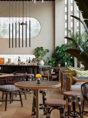 A modern bar area with high stools, a counter with bottles, and a large mirror.