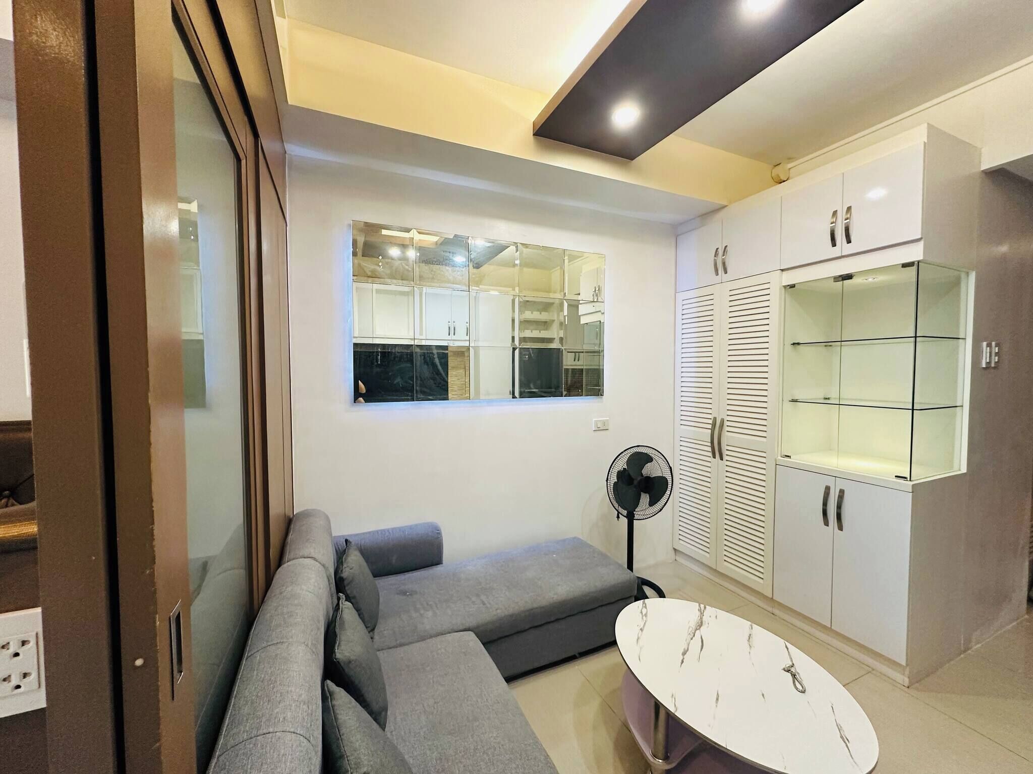 Una sala moderna con un sofá, una mesa de centro y armarios empotrados.