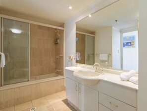 A bathroom with a glass shower enclosure, a sink with a mirror, and a towel rack. - 2nd Avenue Apartments - 13B (2B/2B) (Gold Coast)