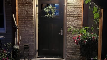 A wooden door with a bell, a mailbox, and a small step leading to the entrance.