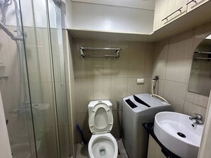 Ein Badezimmer mit Duschkabine aus Glas, Toilette, Bidet und Waschbecken.