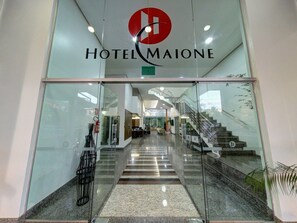 Ein Hotel mit Glasfassade, einer Treppe und einer Rezeption.