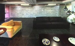 Ein stilvolles Wohnzimmer mit einer Couch, einem kleinen Tisch und dekorativen Tellern.