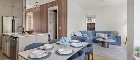 A modern kitchen with a dining area, a built-in oven, and a large window.