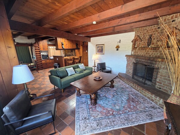 A cozy living area with a sofa, a wooden coffee table, and a fireplace.