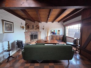 A cozy living room with a fireplace, a television, and a comfortable sofa. - Unique 2-bedroom Castle house near U of A (Tucson)