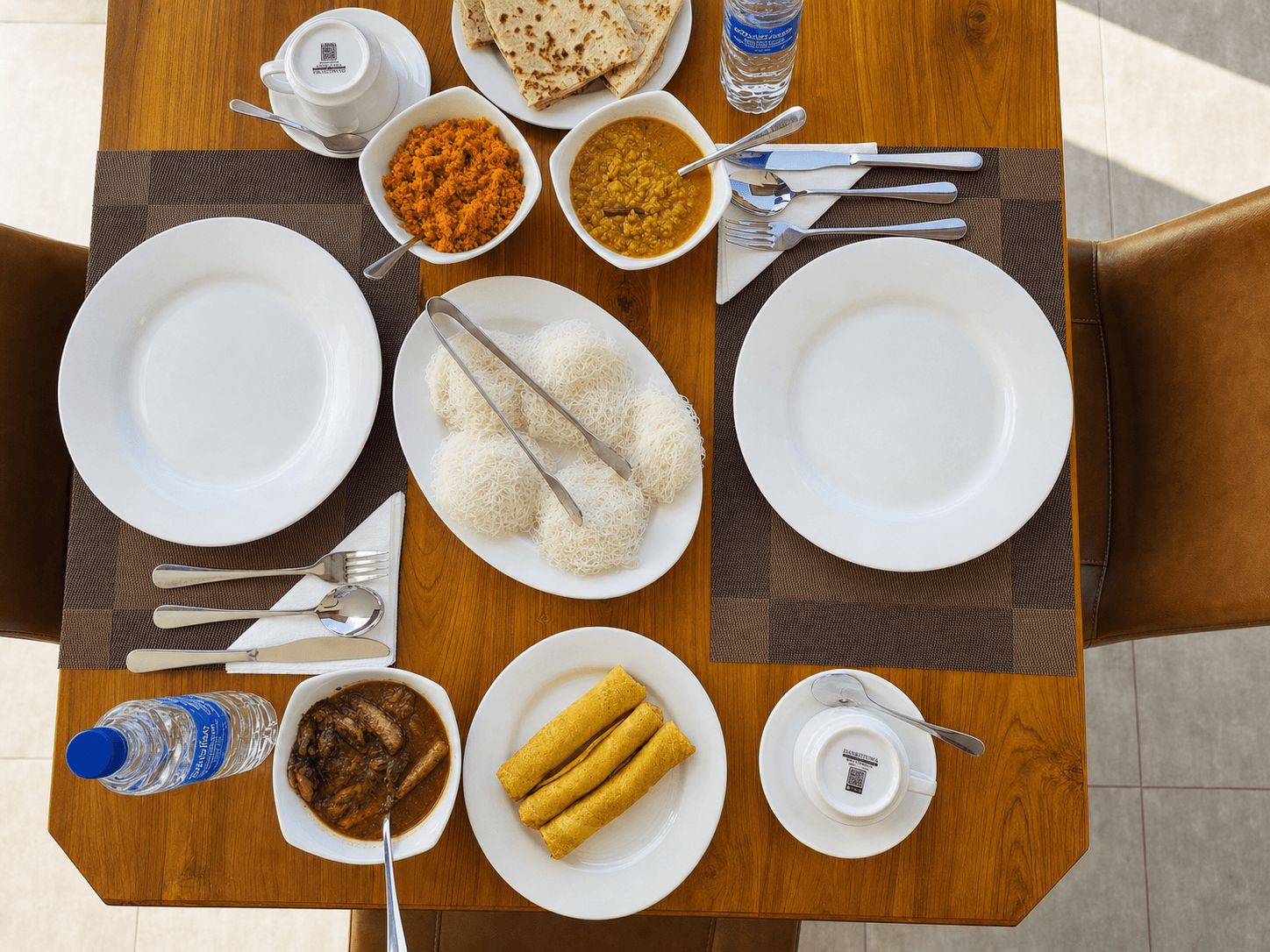 Una mesa de comedor con platos, tazones y cubiertos, que sugiere un ambiente para comer.