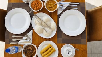 A dining table with plates, bowls, and utensils, suggesting a meal setting.