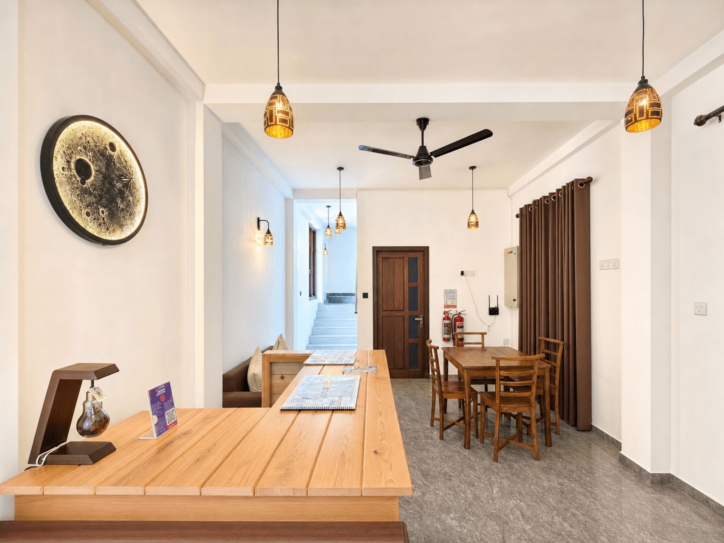 Una cocina moderna con encimera de madera, luces colgantes y ventilador de techo.