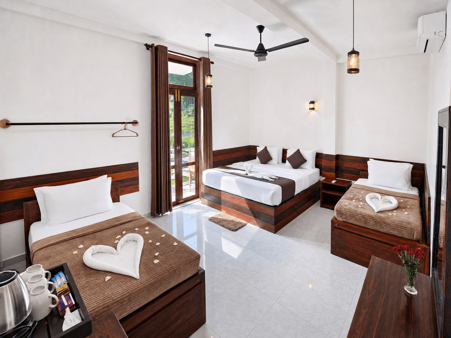 A hotel room with a bed, a desk, a chair, a coffee maker, and a window with curtains.
