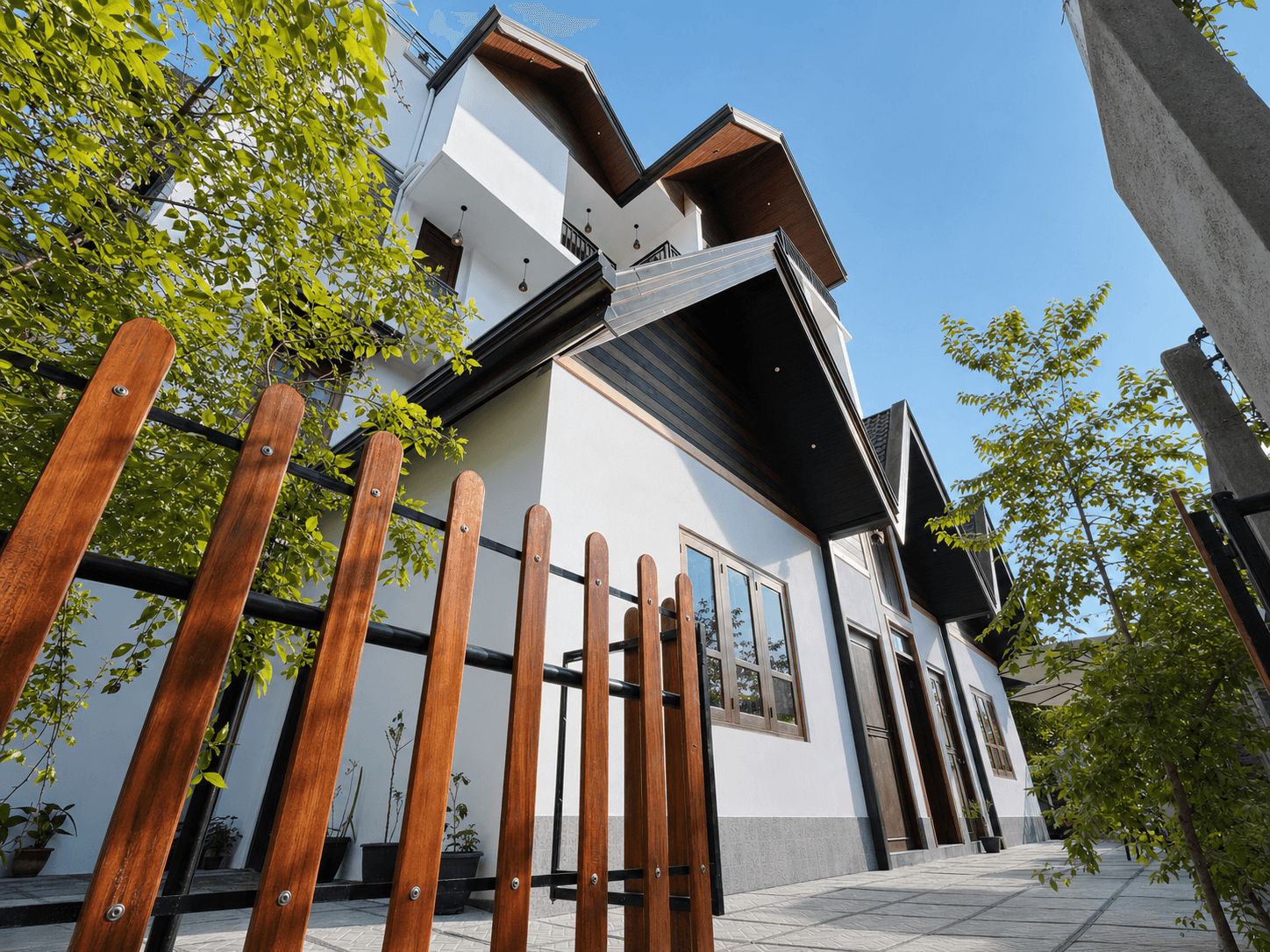 Un bâtiment moderne à deux étages, doté d’une façade blanche, de grandes fenêtres et d’un toit en pente.