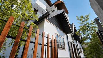 Un bâtiment moderne à deux étages, doté d’une façade blanche, de grandes fenêtres et d’un toit en pente.