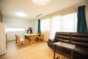 A compact living space with a dining area, a sofa, and a kitchenette. - Aoba Residence ASAHI: 2-Minute Walk to Nishikujo Subway Station, 100 sqm, 4-Bedroom Residence Near USJ (大阪市)