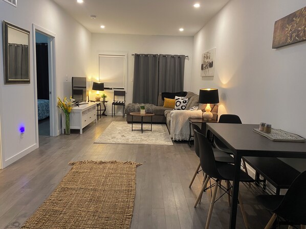 A modern living room with a sofa, coffee table, and dining area.