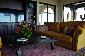 A living room with a sofa, coffee table, and decorative items. - Ocean and Mountain View Villa (Provincia de Guanacaste)