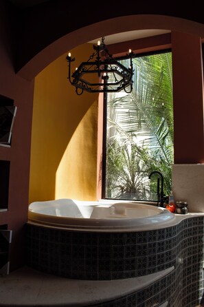 A bathroom with a freestanding bathtub, a window with a view of palm trees, and a decorative light fixture. - Ocean and Mountain View Villa (Provincia de Guanacaste)