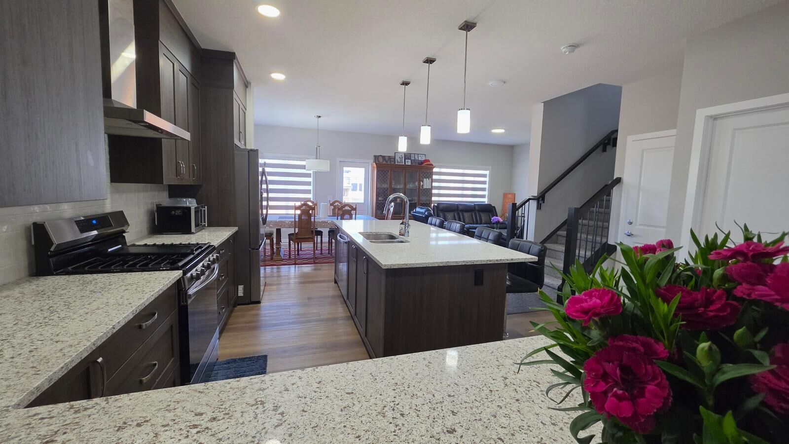 A modern kitchen with granite countertops, stainless steel appliances, and a central island.