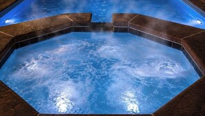 A hot tub with a geometric design, surrounded by dark tiles. - Maple Estate Private Pool, Hot Tub & Resort-Style Backyard (Odessa)