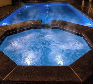 A hot tub with a geometric design, surrounded by dark tiles. - Maple Estate Private Pool, Hot Tub & Resort-Style Backyard (Odessa)