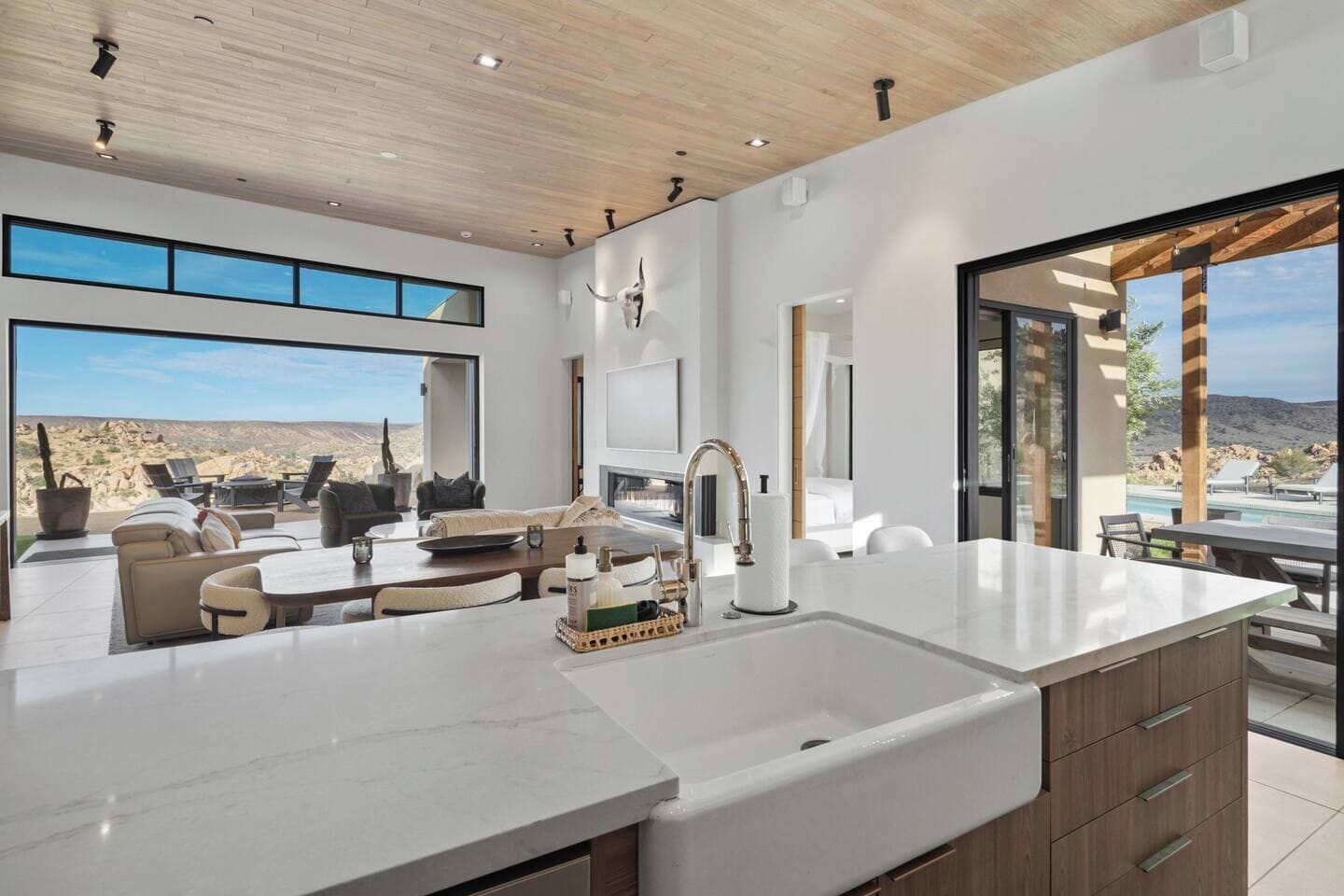 Una cocina moderna con una isla grande, un comedor con vistas y un espacio de sala con chimenea.
