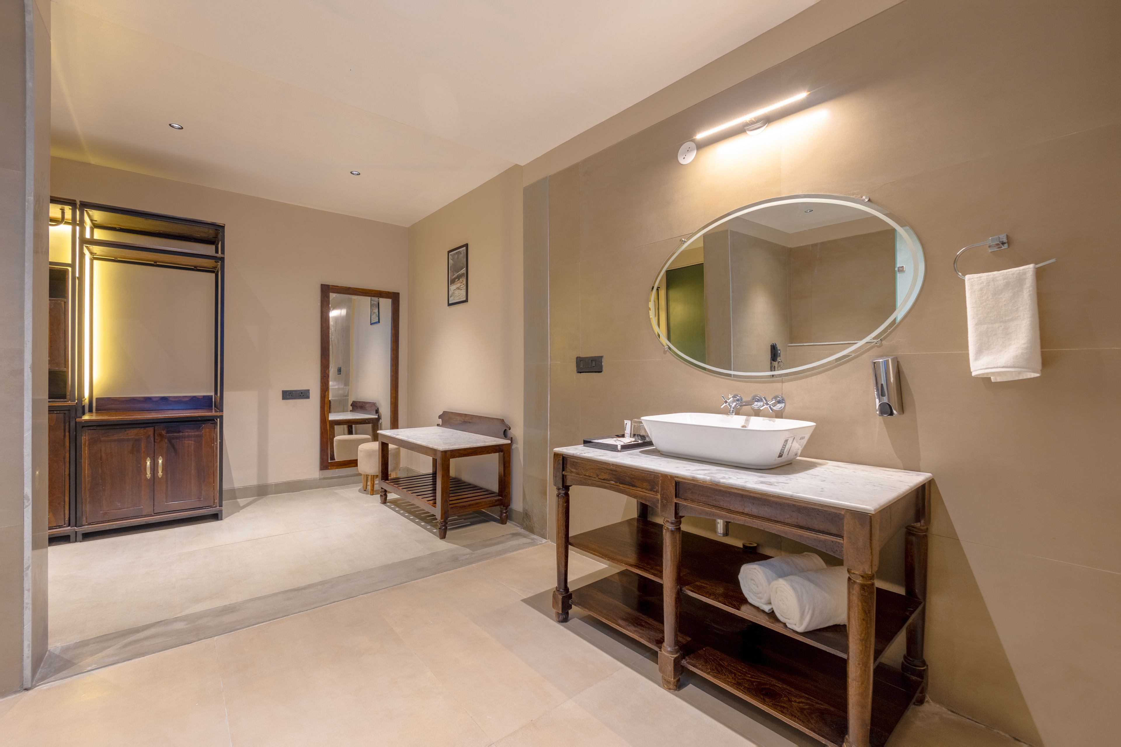 Un baño moderno con tocador, un espejo grande y un perchero para toallas.