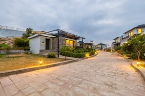 A residential street with houses, a paved walkway, and street lamps. - Sterling Leopard Haven Jawai (Bali)