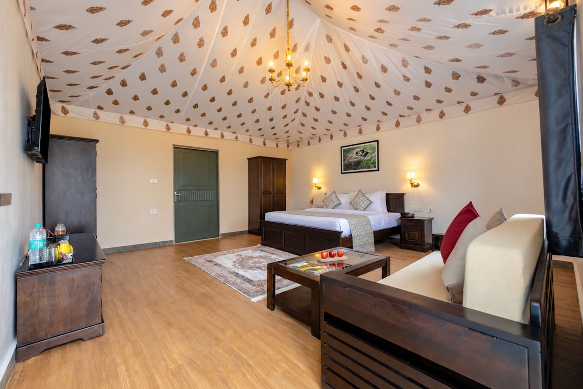 A hotel room with a bed, a sofa, a coffee table, a TV, and a wardrobe.