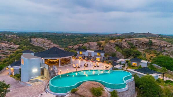 Un resort con piscina, mobiliario exterior y vistas del paisaje circundante.