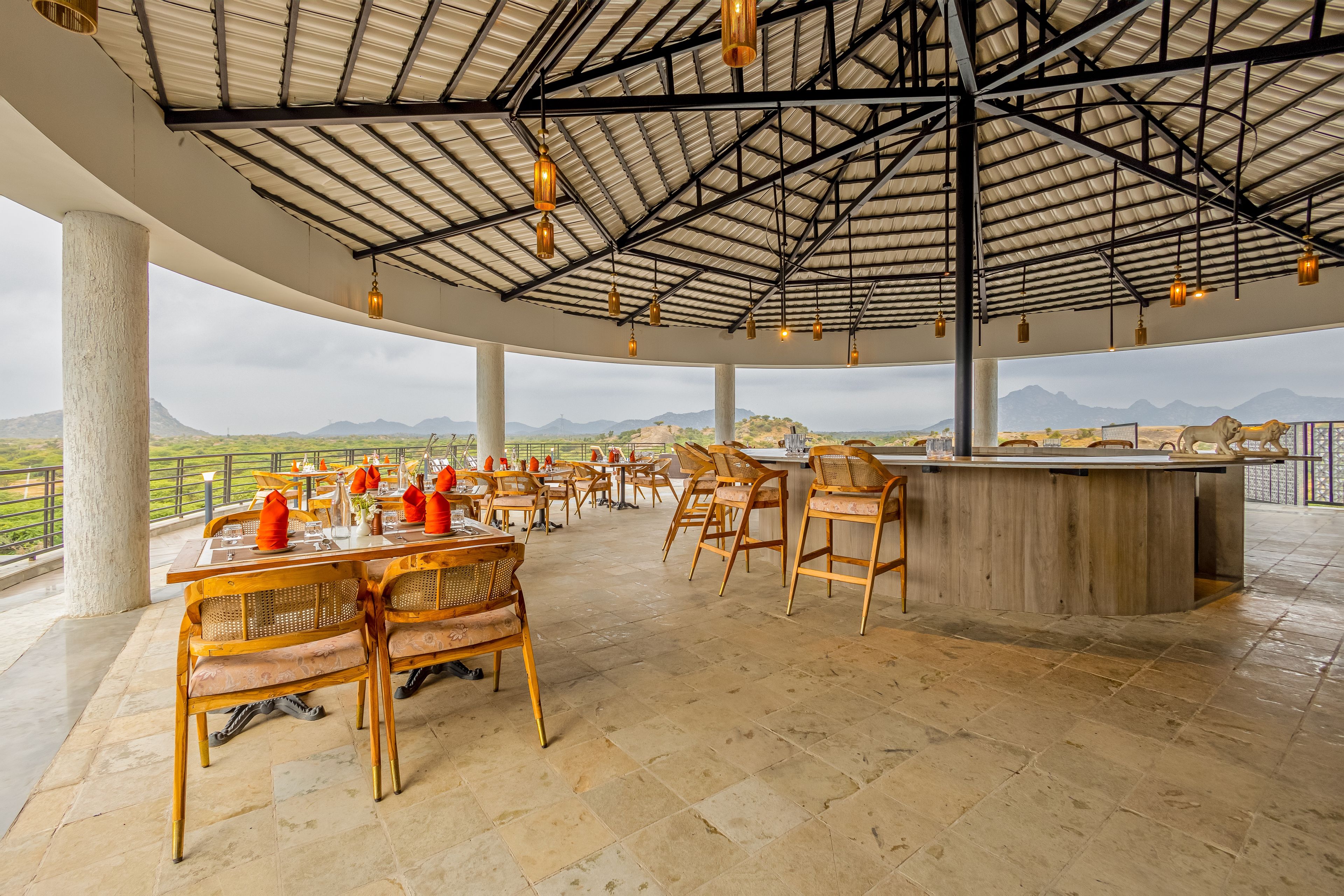 A spacious outdoor dining area with high ceilings and a view of the landscape.
