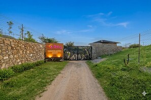 Un chemin de terre mène à une entrée fermée par un portail, sur laquelle est apposée une plaque indiquant « Sterling Leopard Haven Jawai ».