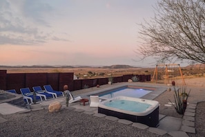 A backyard with a swimming pool, lounge chairs, a hot tub, and a view of the desert landscape. - Pool, Hot Tub, Stars, Views, Yoga Pad, Bocce, BBQ (Joshua Tree)
