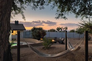 A backyard with a hammock, outdoor seating, and a view of the sunset. - Black Rock Retreat - Desert Escape with Pool, Spa & Hammocks (Yucca Valley)