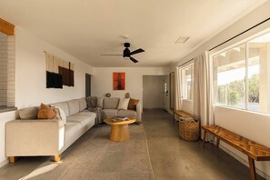 A modern living room with a sofa, coffee table, and a ceiling fan.