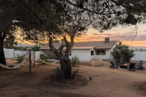 A residential area with a house, a hammock, outdoor seating, and a view of the sunset. - Black Rock Retreat - Desert Escape with Pool, Spa & Hammocks (Yucca Valley)