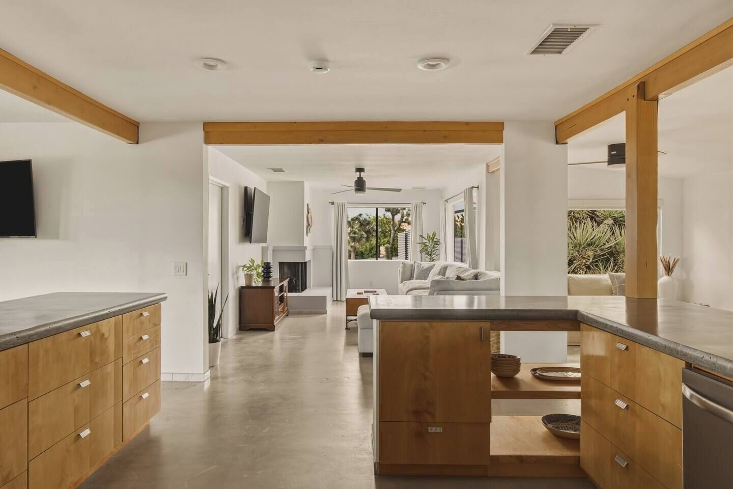 Une cuisine moderne avec des meubles en bois, un îlot central et un coin repas comprenant un canapé et une cheminée.