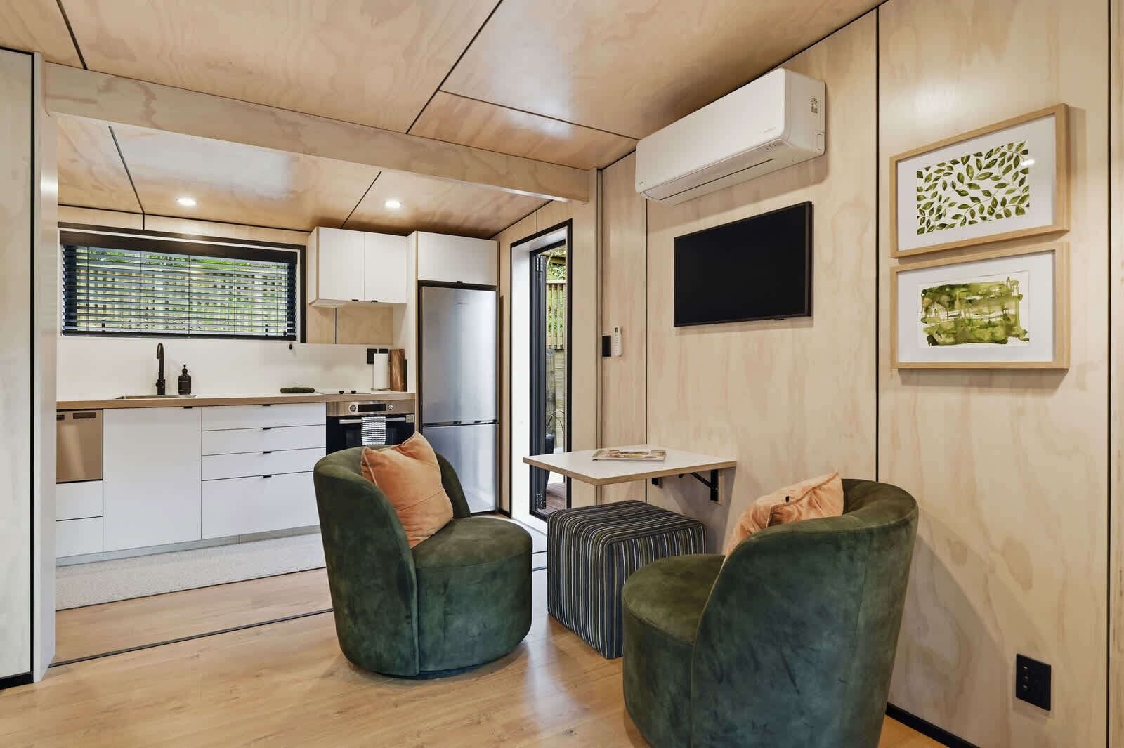 Ein modernes Interieur mit Küche, Sitzgelegenheit und Kunstwerken.