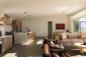 A modern living space with a kitchen, dining area, and seating area. - Pool, Spa, Sauna, Sunken Fire Pit, Amazing Views (Yucca Valley)